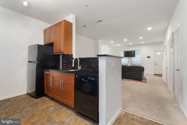 kitchen featuring carpet, kitchen peninsula, tasteful backsplash, sink, and black appliances