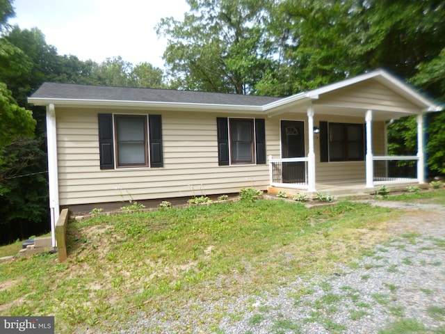 ranch-style home with covered porch and a front yard