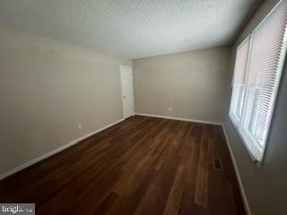 unfurnished room featuring dark hardwood / wood-style floors