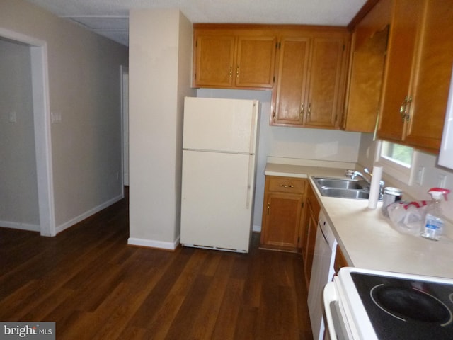 kitchen featuring dark hardwood / wood-style flooring, white appliances, and sink