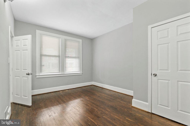 unfurnished room featuring dark wood-type flooring