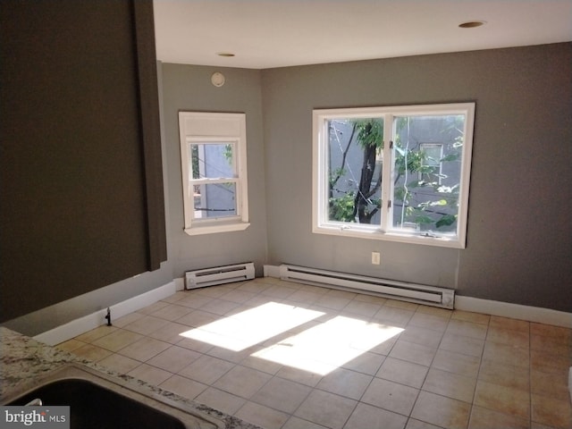 spare room with a baseboard heating unit and light tile patterned floors