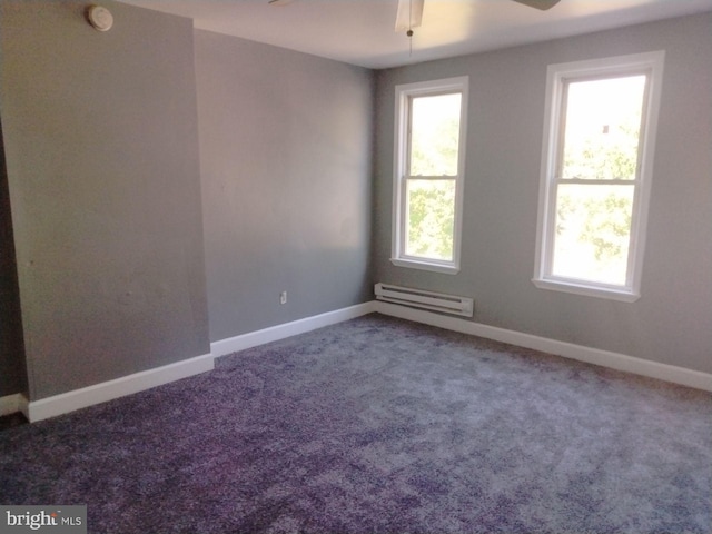 carpeted empty room featuring ceiling fan and a baseboard heating unit