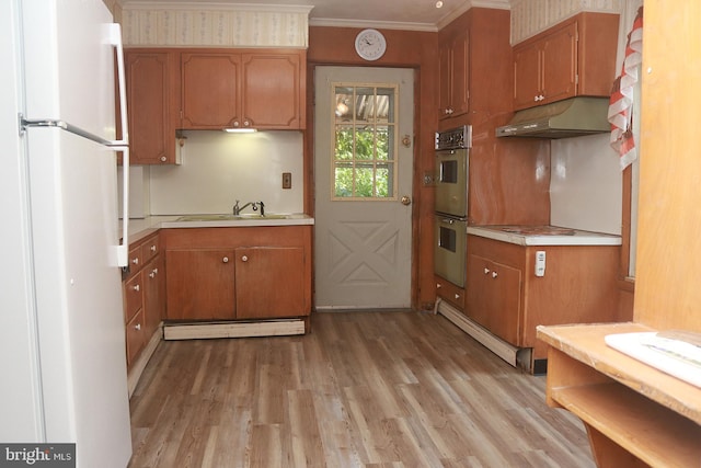 kitchen featuring white refrigerator, ornamental molding, light wood-type flooring, sink, and stainless steel double oven