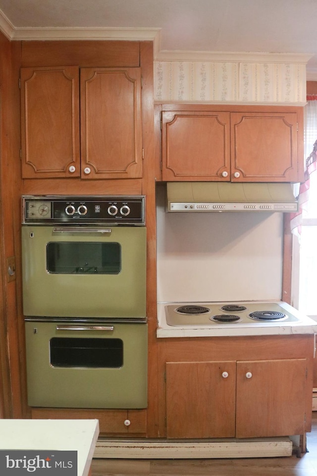 kitchen featuring double wall oven, hardwood / wood-style floors, ornamental molding, and white electric cooktop