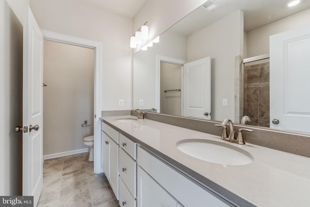 bathroom featuring vanity, a shower with shower door, and toilet