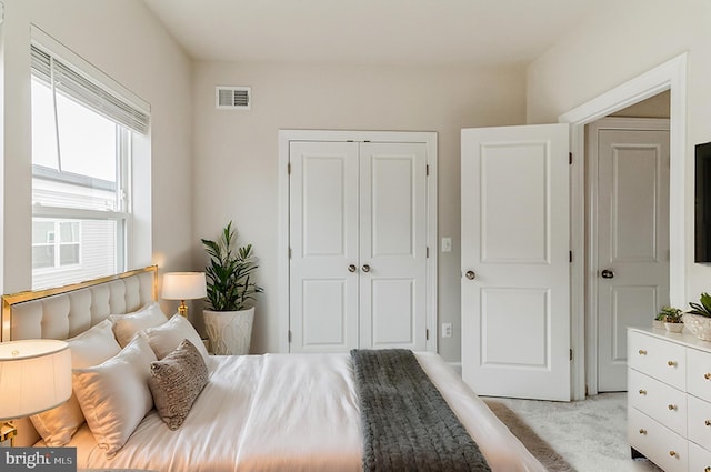 bedroom featuring light carpet and a closet