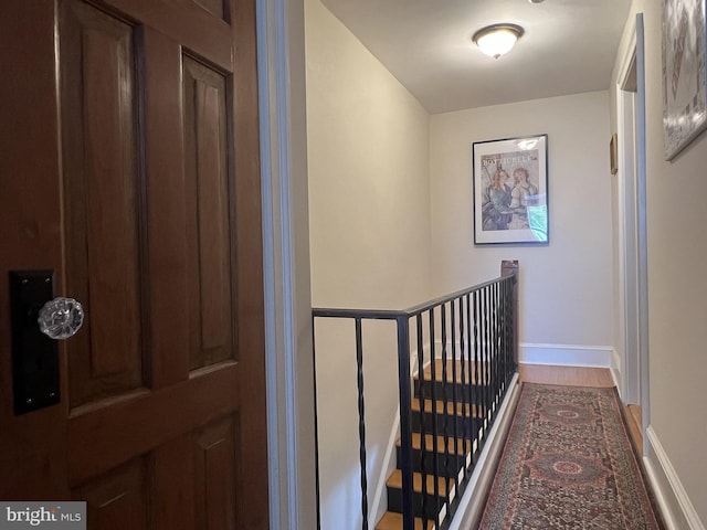 corridor with hardwood / wood-style flooring