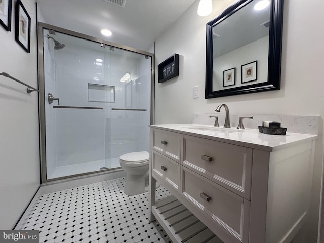 bathroom with vanity, toilet, and a shower with shower door