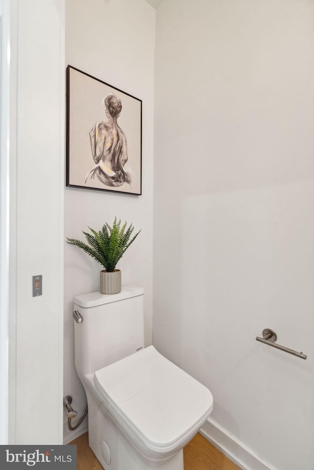 bathroom with hardwood / wood-style flooring and toilet