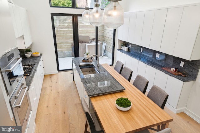 kitchen featuring sink, light hardwood / wood-style floors, white cabinets, and stainless steel appliances