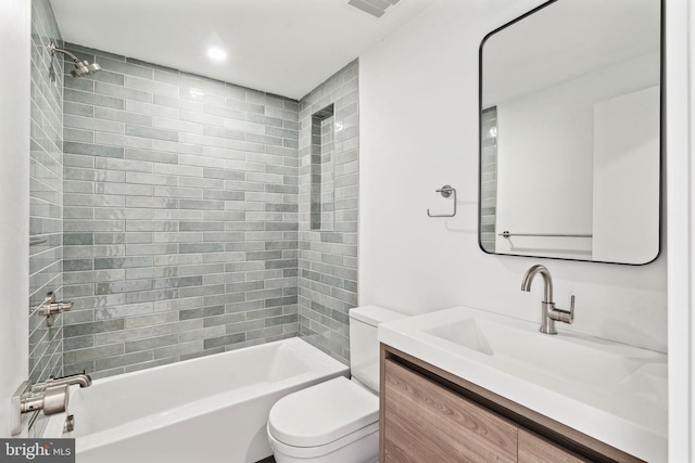 full bathroom featuring tiled shower / bath, vanity, and toilet