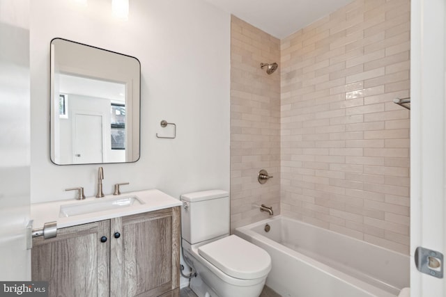 full bathroom featuring tiled shower / bath combo, vanity, and toilet