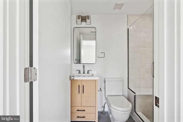 bathroom with vanity, toilet, and an enclosed shower