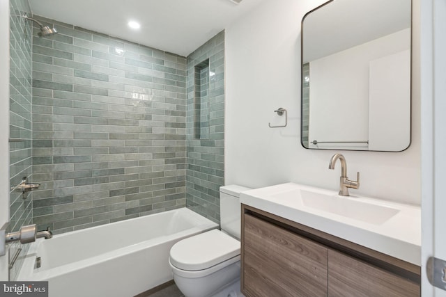 full bathroom with vanity, tiled shower / bath combo, and toilet