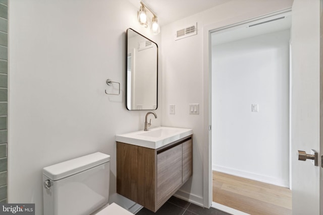 bathroom with tile patterned flooring, vanity, and toilet