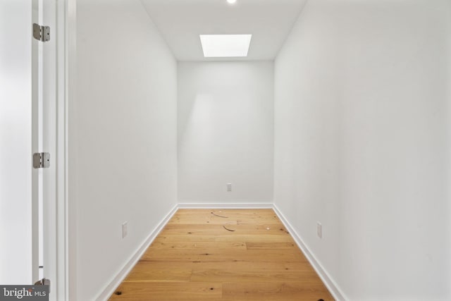 interior space with a skylight and light hardwood / wood-style flooring