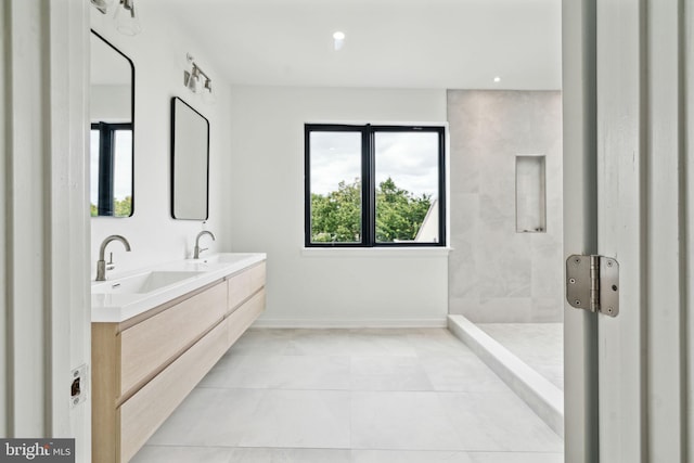 bathroom featuring tile patterned flooring, vanity, and tiled shower