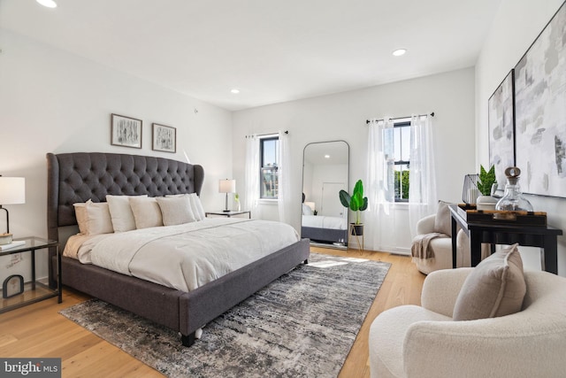 bedroom with multiple windows and light hardwood / wood-style flooring