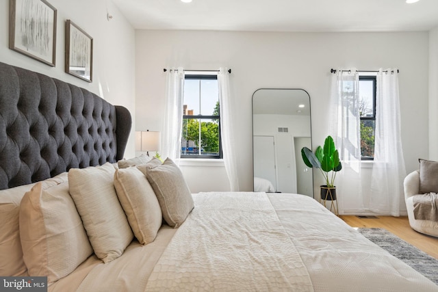 bedroom with multiple windows and light wood-type flooring