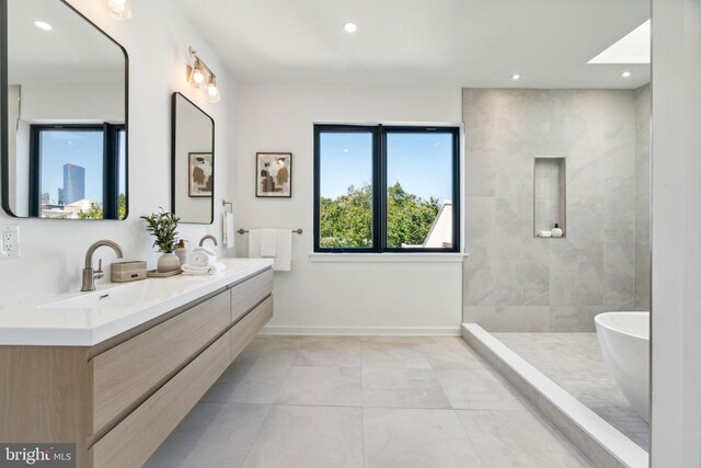 bathroom with vanity and shower with separate bathtub