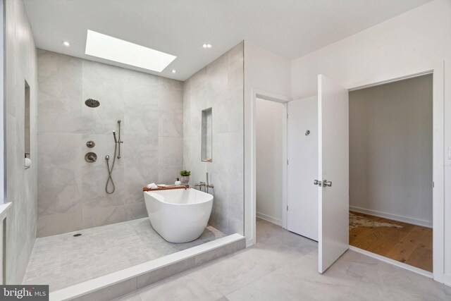 bathroom with a skylight, separate shower and tub, and wood-type flooring