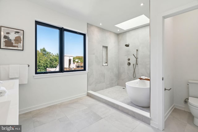 bathroom with a healthy amount of sunlight, toilet, a skylight, and separate shower and tub