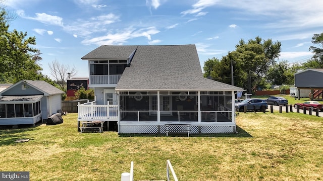 rear view of property featuring a sunroom and a yard