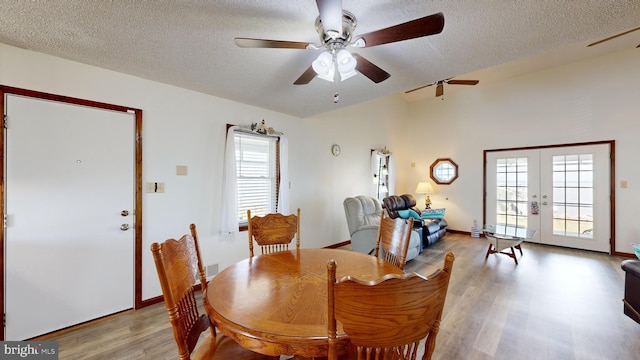 dining room featuring french doors, a textured ceiling, light hardwood / wood-style flooring, and plenty of natural light