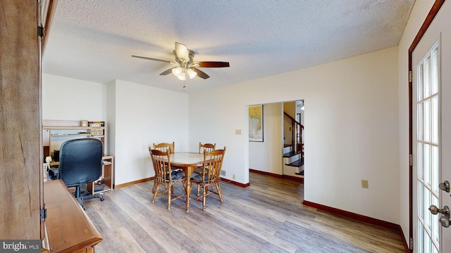 dining area featuring ceiling fan, light hardwood / wood-style floors, and a textured ceiling