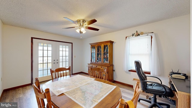 dining area with ceiling fan, light hardwood / wood-style floors, a textured ceiling, and french doors