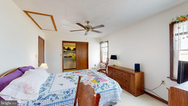 carpeted bedroom featuring multiple windows, a textured ceiling, and ceiling fan