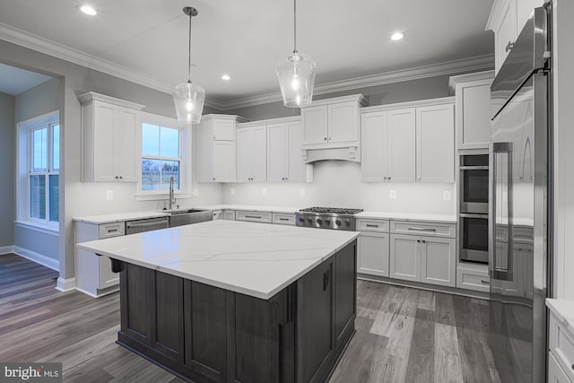 kitchen featuring light stone countertops, pendant lighting, white cabinetry, stainless steel appliances, and sink