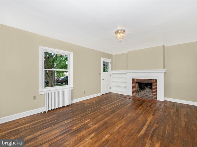 unfurnished living room with radiator, a fireplace, and dark hardwood / wood-style floors