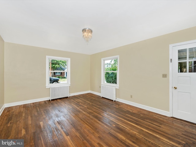 interior space featuring dark wood-type flooring, a wealth of natural light, and radiator heating unit