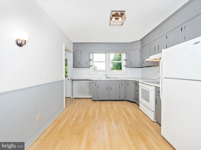 kitchen with gray cabinets, sink, white appliances, and radiator heating unit