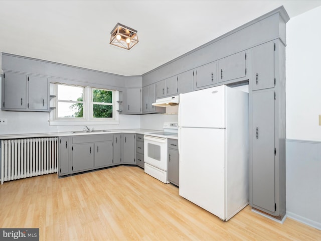 kitchen with gray cabinetry, sink, radiator heating unit, and white appliances