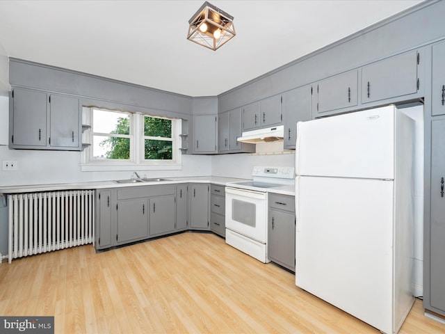 kitchen featuring gray cabinets, white appliances, light wood-type flooring, radiator, and sink