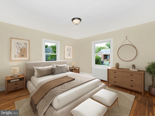 bedroom featuring dark wood-type flooring, multiple windows, and radiator heating unit