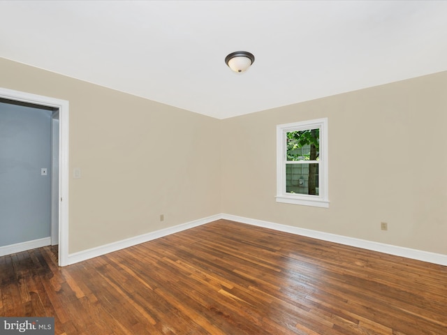 unfurnished room with dark hardwood / wood-style flooring