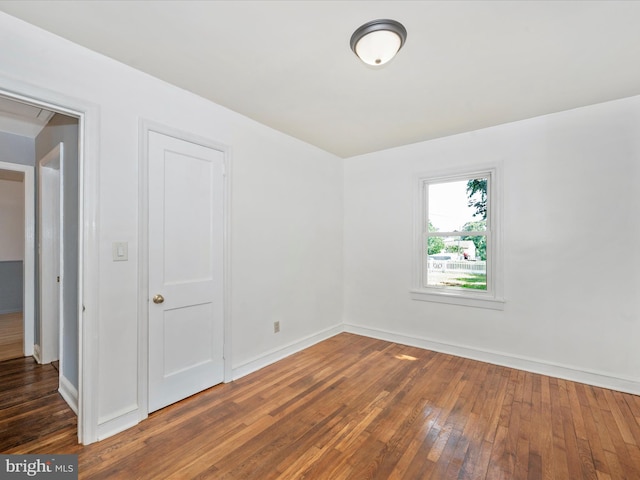 unfurnished room with dark wood-type flooring