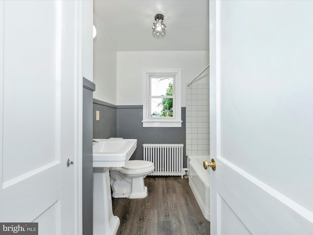 bathroom featuring toilet, radiator,  shower combination, and hardwood / wood-style flooring