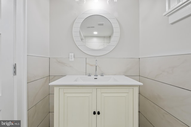 bathroom featuring vanity and tile walls