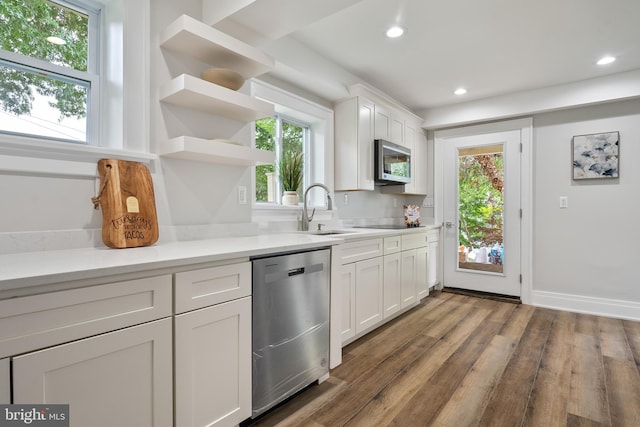 kitchen featuring sink, dark hardwood / wood-style flooring, stainless steel appliances, and white cabinetry