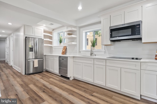 kitchen featuring sink, white cabinetry, stainless steel appliances, and light hardwood / wood-style floors