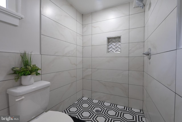 bathroom featuring toilet and a tile shower