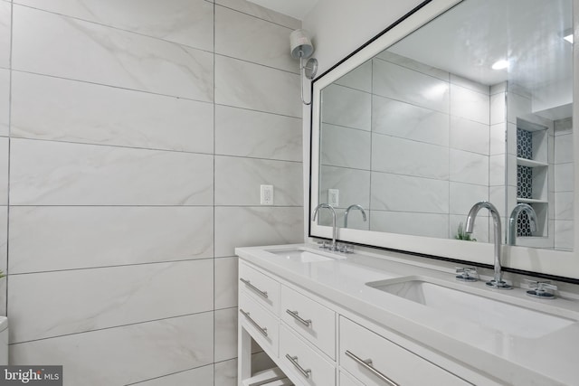 bathroom with double vanity, tile walls, and toilet