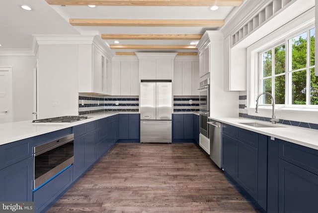 kitchen with white cabinetry, dark wood-type flooring, beamed ceiling, appliances with stainless steel finishes, and sink