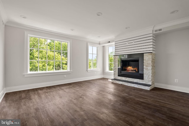 unfurnished living room featuring a stone fireplace, dark wood-type flooring, and crown molding