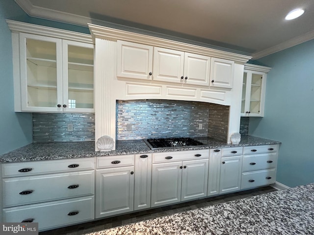 kitchen featuring gas cooktop, tasteful backsplash, crown molding, dark stone countertops, and white cabinets